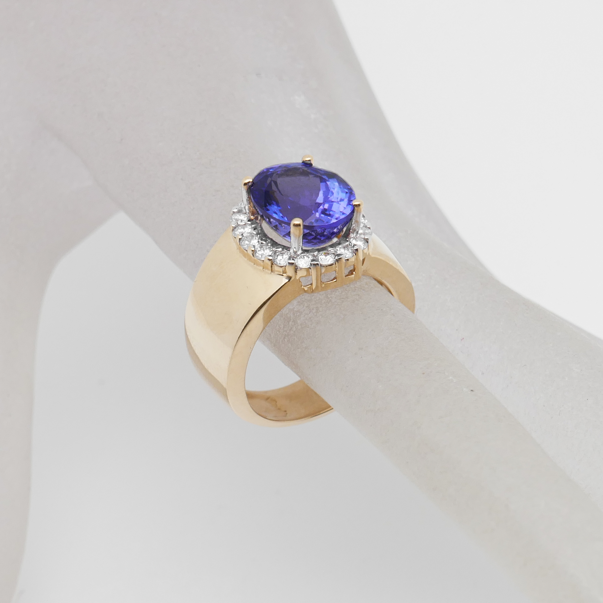 Goldring mit blauem Stein am Finger getragen