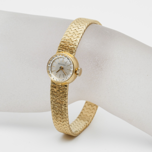 Damenarmbanduhr von Bucherer aus 18 Karat Gelbgold an einer weißen Schmuckbüste