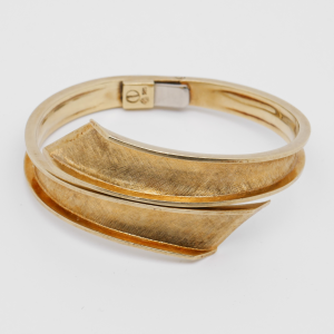 Geschlossener Armreif aus 585 Gelbgold vor hellem Hintergrund